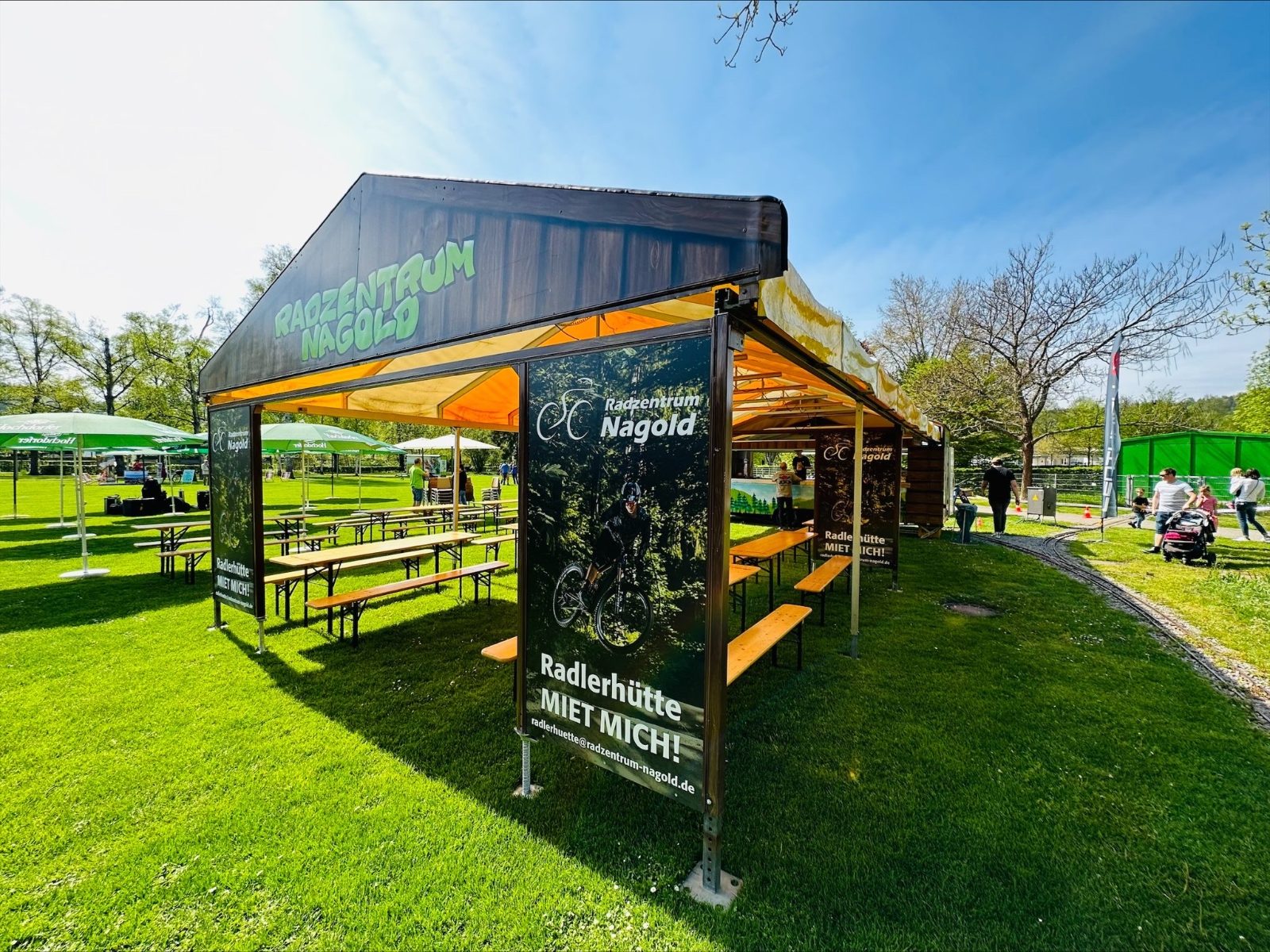 Radlerhütte mit aufgebautem Zelt und Bierbänken auf der Festwiese